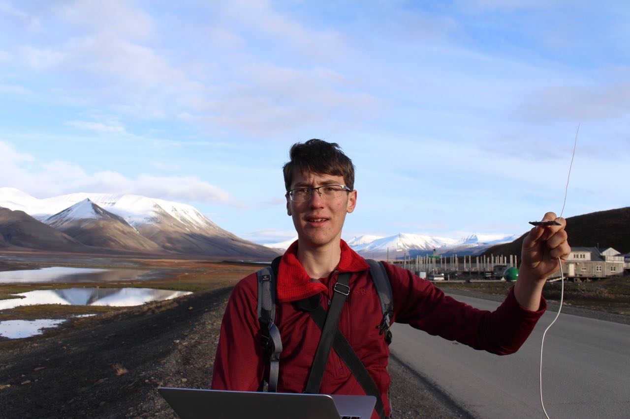 William holding laptop and telemetry receiver in Svalbard